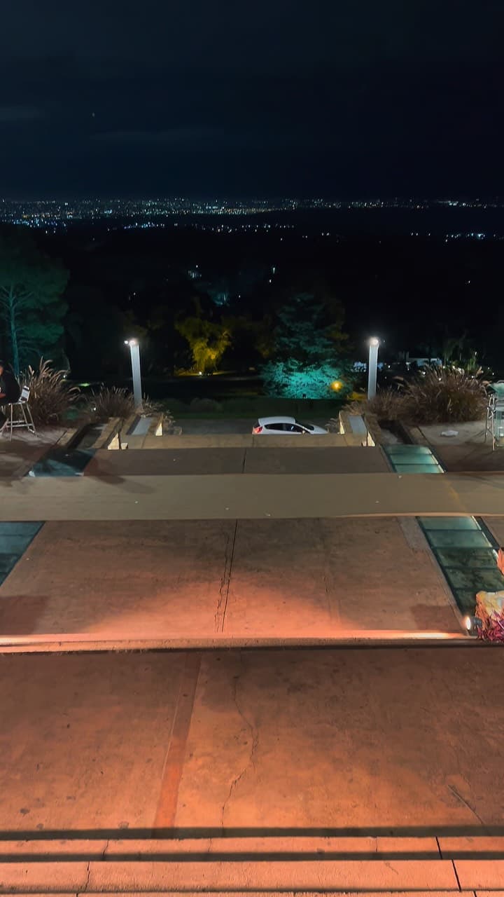 La terraza de noche, con las luces de la ciudad a lo lejos.